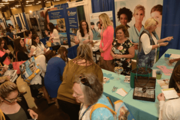 A group of people by a vendor table.
