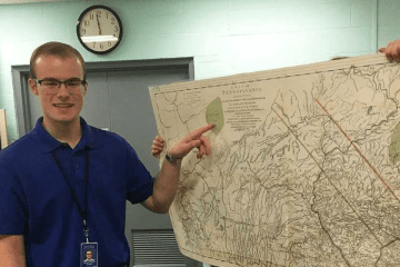 A man pointing to a spot on a map.