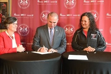 A group of three signing. 