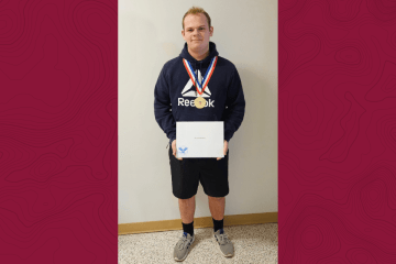 A man standing with an award. 
