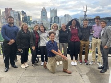 A group of people standing in front of a city outlook. 
