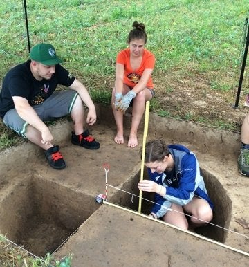 Anthropology students take measurement during summer field school experience