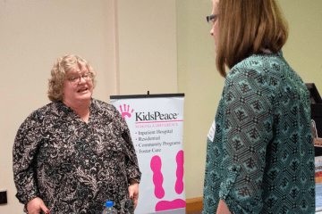 A representative from Kids Peace speaks with a student at a recent Career Expo