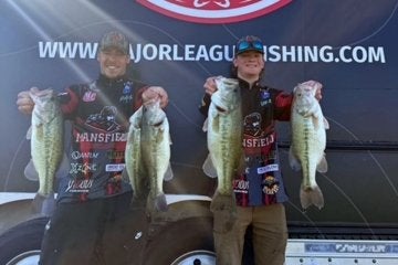 two members of the Mansfield bass fishing team pose with their bass at the national championships