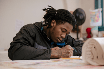 A Visual Arts student at CU-Bloomsburg working intently on a drawing project