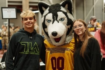 High school students posed with the Huskie mascot during a Commonwealth University-Bloomsburg open house