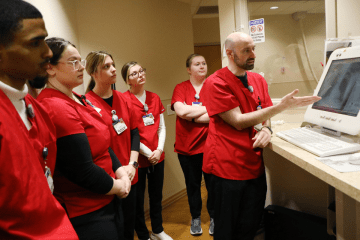 Commonwealth University Mansfield rad tech students at Sayre's Robert Packer Hospital listen to an instructor pointing at an x ray