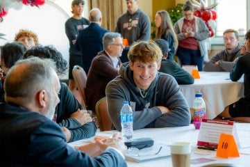 Student talking with alumni at Lock Haven Success in 90! event.