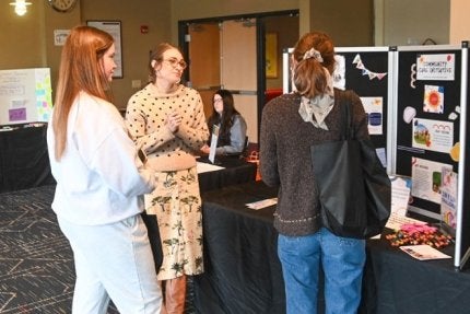 Students chat with a local business owner at the Women's Resource Fair that is held on campus each spring