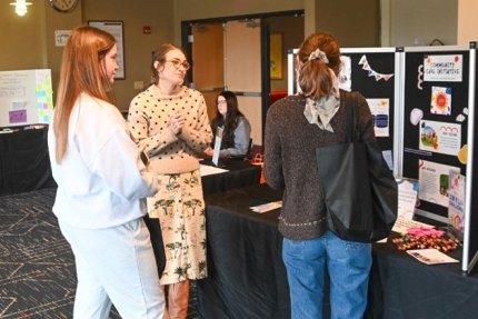 Students chat with a local business owner at the Women's Resource Fair that is held on campus each spring