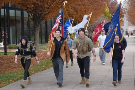 Military and Veteran students carry flags during the Suicide Walk in 2025