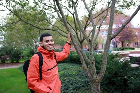 Pedro Frias-Rosario '21 smiling outside, next to tree.