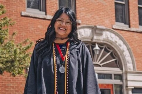 Sarah Hart in graduation regalia smiling at camera