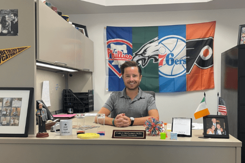 MS School Counseling alumni sitting behind a desk