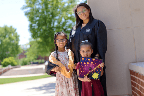 MSW graduate and her children in front of McCormick Hall