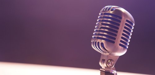 Microphone close-up positioned against purple wall