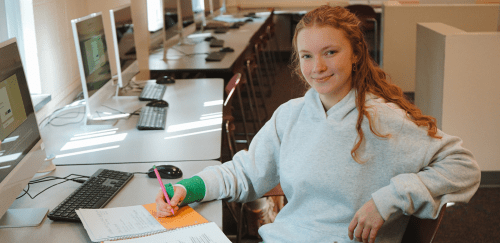 Early College student writing in a notebook