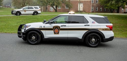 Two Pennsylvania State Police vehicles parked along a street.
