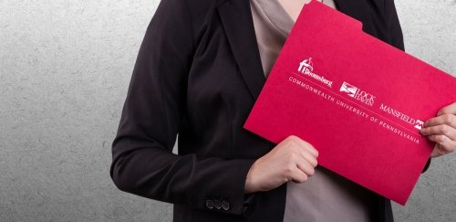 Close-up of woman holding red folder with CU logo.