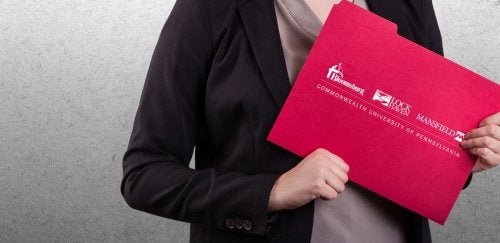 Close-up of woman holding red folder with CU logo.