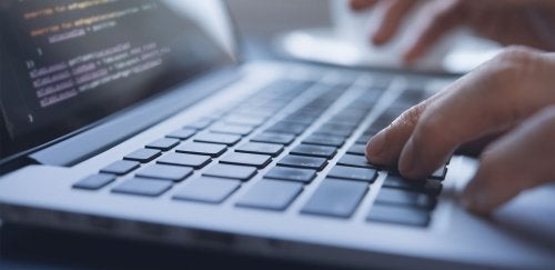 Close-up of person coding on a laptop