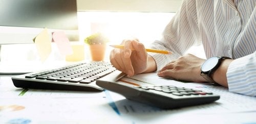 Close-up of a man's hands near a keyboard and calculator.
