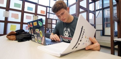 Pre-Med student Finn Purtle studies with his laptop and books.