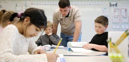 A student teacher from CU-Bloomsburg assists a young student.