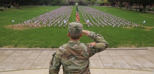 A soldier salutes a display of American Flags on the Bloomsburg academic quad.