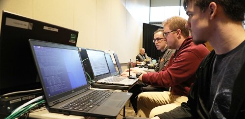 Three males work on laptops at BloomCON '22