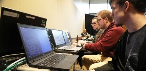 Three males work on laptops at BloomCON '22