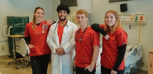 Mansfield nursing students posing together while working in a sim lab.