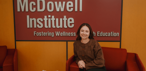 Graduate student sitting in front of the McDowell Institute Office