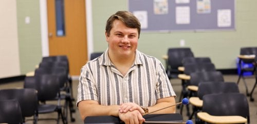 a mansfield music education student stands in a Commonwealth University classroom with chairs in the background