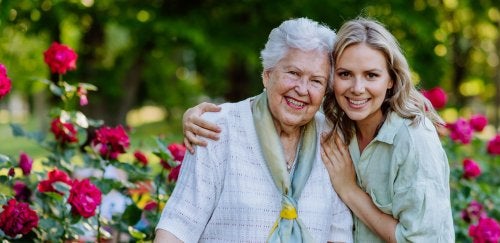 Senior woman with younger woman in rose garden.