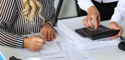 Closeup of hand working on bookkeeping tasks
