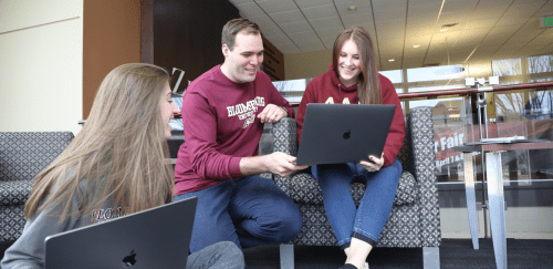 Three students looking at a lap top