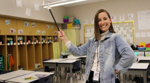Student teacher, Jenna Beiter, poses with a pointer in a classroom