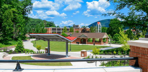 sunny photo of Lock Haven campus showcasing amphitheater space and green area on campus.