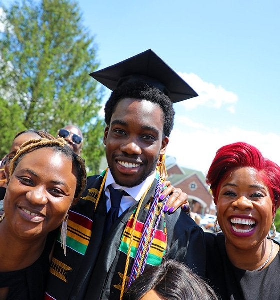 Student at Bloomsburg May 2025 graduation with two family members 