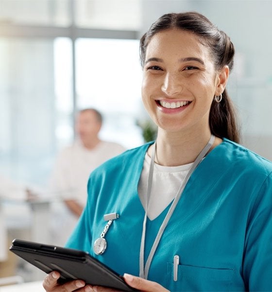Smiling medical staff person holding tablet