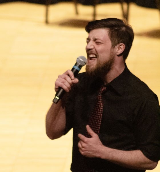 Male singer performing at Mansfield concert.