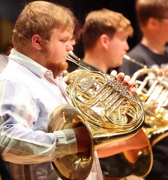 Mansfield student playing french horn during concert.
