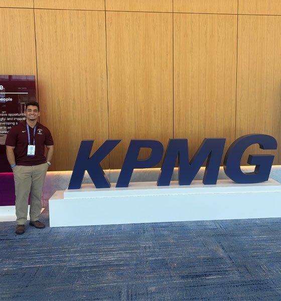 Accounting major Josiah Du standing near KPMG sign.