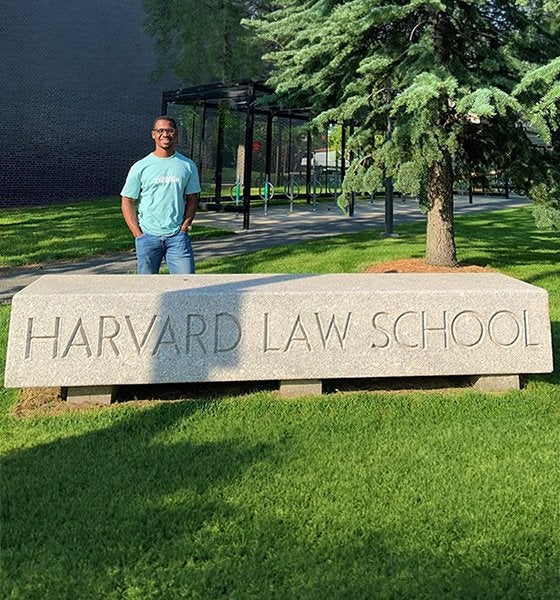 Chanty Gbaye standing behind the Harvard Law School sign