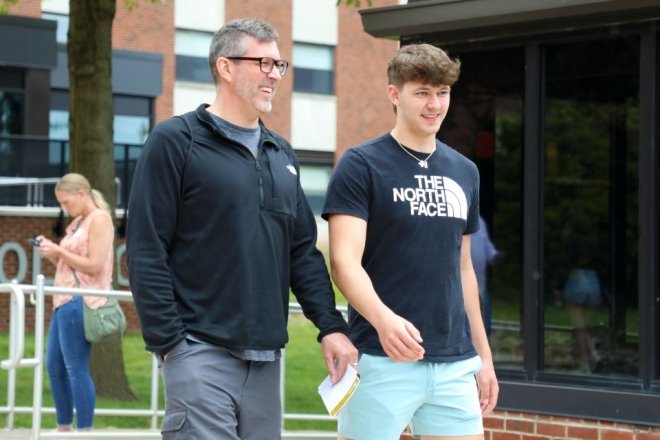 two individuals walk together on campus