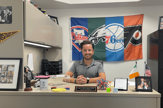 MS School Counseling alumni sitting behind a desk