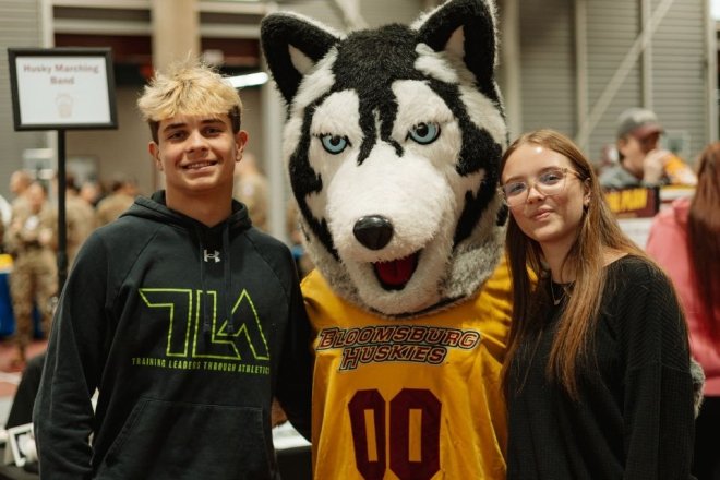 High school students posed with the Huskie mascot during a Commonwealth University-Bloomsburg open house