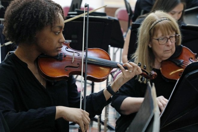 Sanai Castle playing violin with the orchestra.
