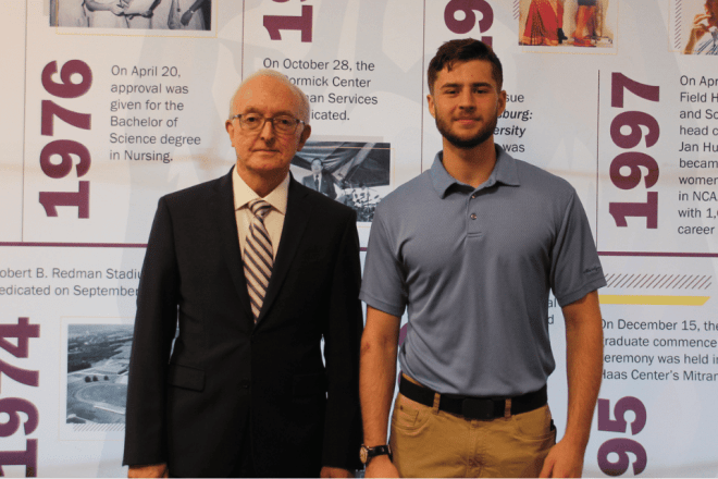 Alum volunteer, Tom Stiner '77 stands with a current Bloomsburg student